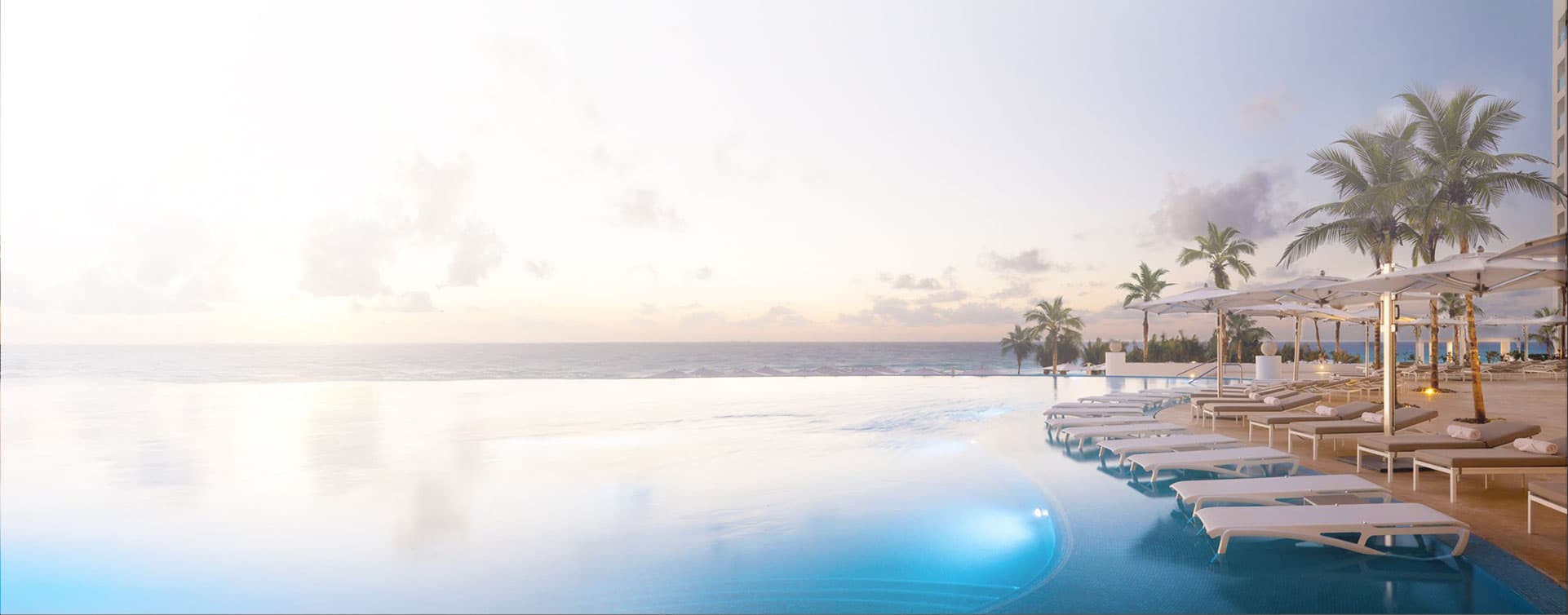 Deux cocktails face à une plage turquoise au soleil couchant